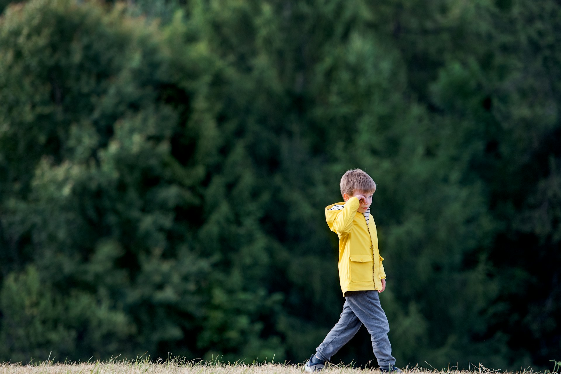 A child is walking while being disappointed.